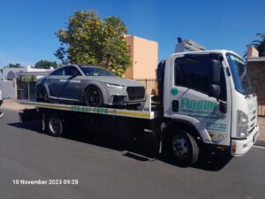 folami towing flatbed truck moving an audi r8
