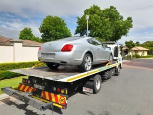 folami towing a chrystler on a flatbed truck