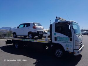 folami towing flatbed truck moving a car